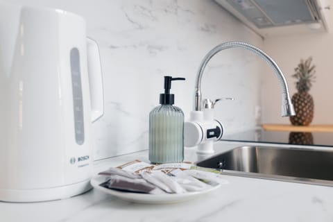A closer look at the functional kitchen setup, including a kettle, sink, and small storage options.