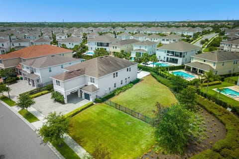 Aerial view of a charming home with lush greenery beside the property, perfect for peaceful walks. The house sits in a serene setting, offering spacious surroundings, natural beauty, and a relaxing atmosphere for a tranquil stay.