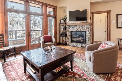 Comfortable living room, with fire place and TV and steps right off to the patio.