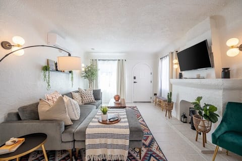 Cozy Living room featuring a large sectional couch, smart 4K UHD TV, and split AC/heater