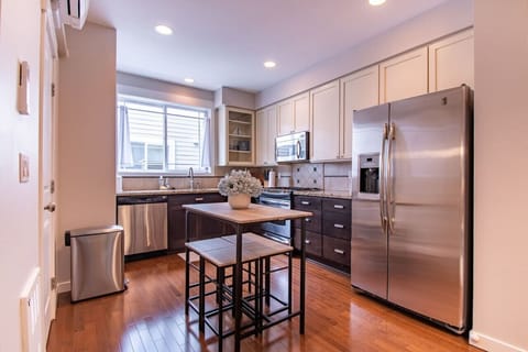 Kitchen equipped with a refrigerator, microwave, oven, dishwasher, and other utensils.