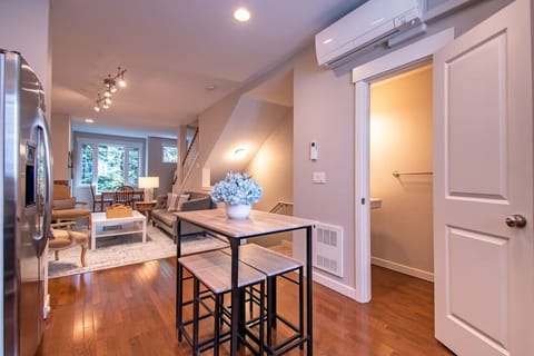 Living area with warm wood floors, a modern table, and plenty of natural light for a welcoming feel.