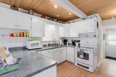 The front door can be seen down the hallway, here we see the pristine kitchen with all the appliances you'll need - not pictured, fridge is across from the kitchen