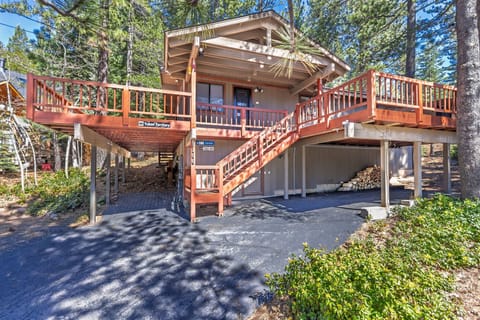 Charming elevated cabin with extensive decking surrounded by towering pines, offering a peaceful forest retreat with convenient parking.