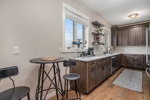 Intimate bistro table by the kitchen, complete with a charming wooden bear-themed tic-tac-toe board. It's a perfect spot for two to dine, play, or have a cozy conversation.