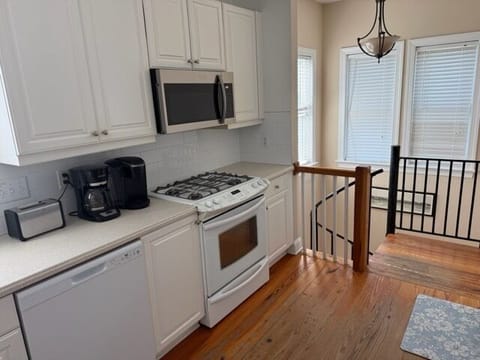Your fully equipped kitchen awaits with gleaming appliances and warm hardwood floors for memorable home-cooked meals.