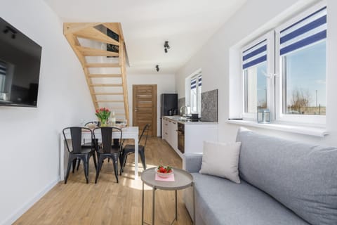 A spacious and bright living room with a comfortable dining table, perfect for shared meals and relaxation.