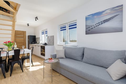 A bright living room corner with a comfortable sofa. The space offers a modern and welcoming vibe.