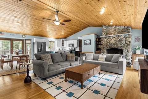 Open-concept kitchen, living, and dining space with high ceilings.