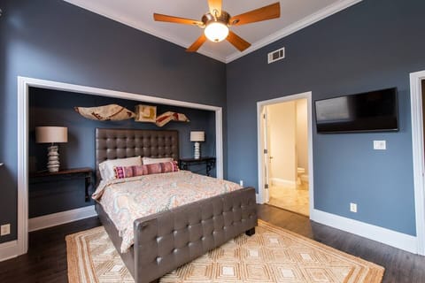 Unwind in luxury in this exquisite cozy primary bedroom, featuring a  flat screen TV, refreshing ceiling fan 