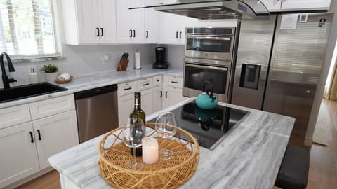 `Chef`s Delight in a Cozy Corner: This modern kitchen blends sleek design with homely comfort, perfect for both the ambitious home chef and those who love to entertain. Marble countertops and state-of-the-art appliances await in your home away from home. 