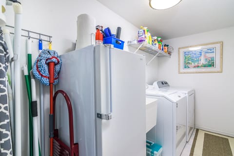 Utility room with washer, dryer, mop sink, and extra refrigerator