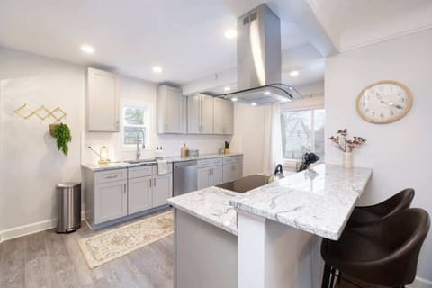 - Kitchen with marble style counters and bar stools   - Stainless steel appliances and ample cabinetry   - Bright lighting highlights modern cooking space  