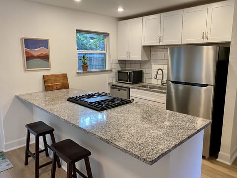 Renovated kitchen with updated cabinets and large granite island