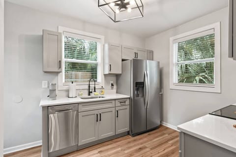 Full kitchen with two large windows overlooking the privacy fenced back yard.