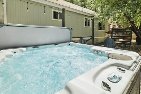 Private outdoor hot tub, surrounded by tall pines, perfect for relaxing under the trees after a day of adventure—enjoy peaceful forest views, fresh air, and a truly rejuvenating stay.