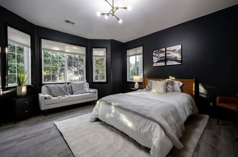 Comfortable queen size bed with large windows and black out curtains.