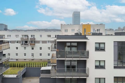 A view of the residential neighborhood with modern apartment buildings. The open sky and city setting create a vibrant urban vibe.