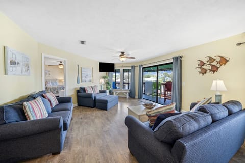 The living room offers ample, comfortable seating and features a flat screen television and views of Grand Lagoon.