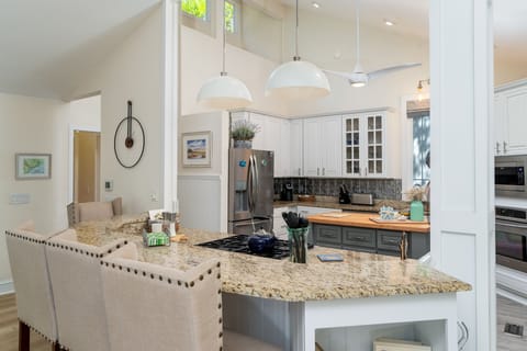 The kitchen is open to the dining area. The island has seating for three.