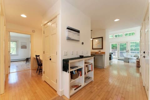 From the front entry, a central hall leads to common areas and a hallway to the left leads to work space, full bath, and primary bedroom.