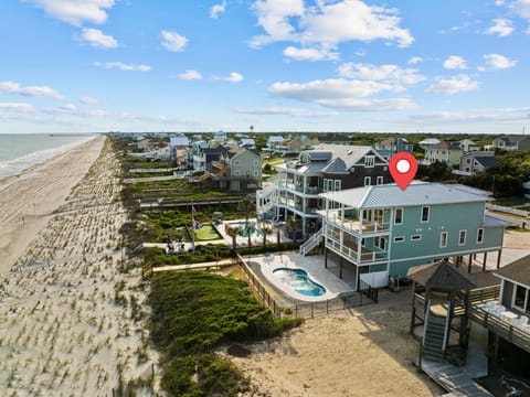 Stunning oceanfront property with private pool sits directly on pristine sandy beach, offering panoramic coastal views and beach access.