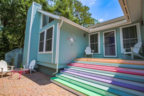 The steps to the front porch of Love Blooms Here are painted with playful rainbow colors.