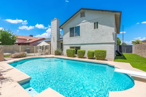 Backyard offers it all: Pool with diving board, dedicated patio, and grassy area