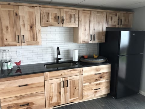 Kitchenette area with wet bar, custom cabinets, game table, and refrigerator.