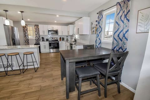 The kitchen boasts modern appliances and plenty of counter space, complemented by a convenient bar counter. Adjacent to it is a cozy 4-seater dining area, perfect for enjoying meals or gathering with friends and family.