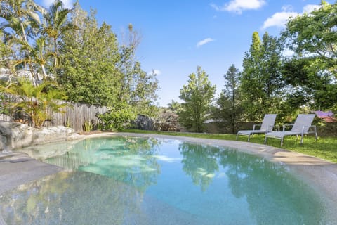Private in-ground pool with easy-entry ramp surrounded by tropical gardens