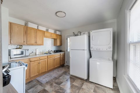 Fully equipped kitchen with everything you need, including a stove/oven, refrigerator, microwave, air fryer, blender, cookware, and a coffee bar stocked with coffee, creamer, and sugar. Stackable washer and dryer included.