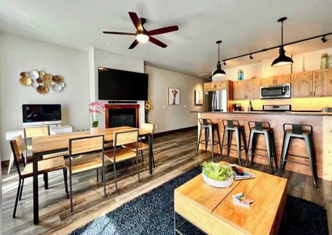 Great room with Kitchen, Living area with gas fireplace, flatscreen Tv, desk with monitor and a Dining area