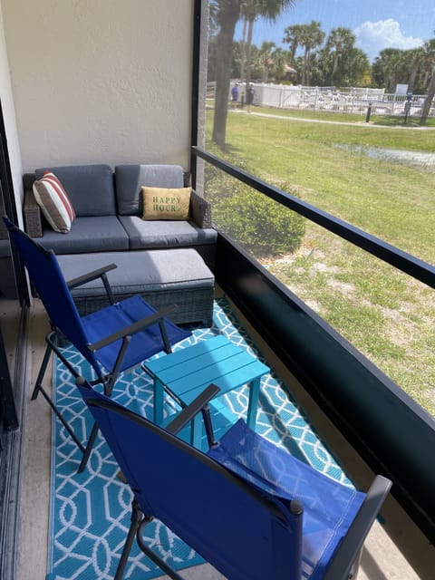 screened in patio with a screen door overlooking the beach pool and beach path 