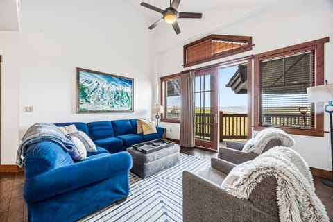 Open-plan living — cobalt sectional and slope-view French doors.