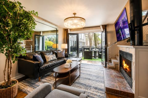 From the living room, enjoy a clear view of the stairs leading to the loft space, complemented by a cozy fireplace and a large smart TV, creating a perfect blend of comfort and style.