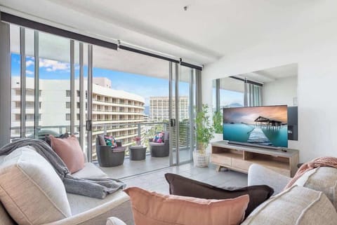 Relax in the light-filled living area where floor-to-ceiling glass frames marina views and opens directly onto the balcony for breezy indoor-outdoor living.
