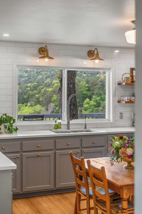 Full kitchen with breakfast table and window overlooking the deck and mountains.