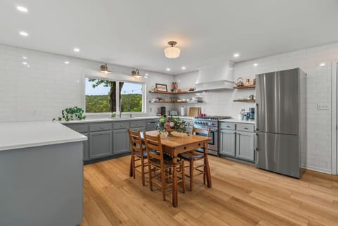 Full kitchen with breakfast table and window overlooking the deck and mountains.