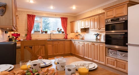 Four Pines Lodge dining table set for breakfast with kitchen