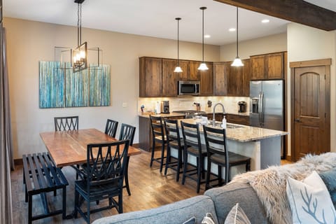 - Spacious kitchen and dining area with modern wood cabinetry   - Granite countertops and island seating for family gatherings   - Open layout with stainless steel appliances and warm lighting