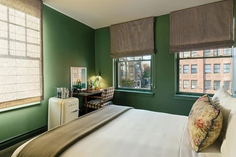 Sink into cloud-soft bedding with city views and calm greens.