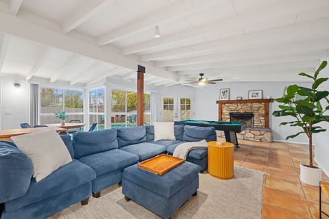 “Bright and spacious living room with sectional sofa, fireplace, and smart TV — perfect for relaxing together.