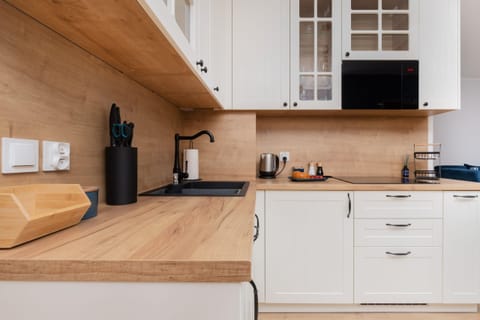 A detailed view of the kitchen, highlighting wooden countertops and built-in appliances.

