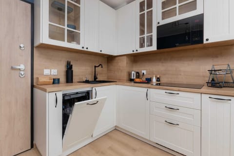 A close-up of the kitchen cabinets, showing an assortment of cups and neatly organized shelving.

