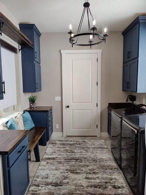 Beautiful laundry room with sink, many cabinets, washer/dryer and extra fridge.