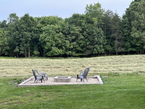 Fire pit area in the backyard that is stocked with wood