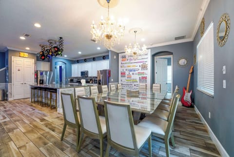 Spacious dining room with chic chandeliers and a musical theme, perfect for large gatherings.
