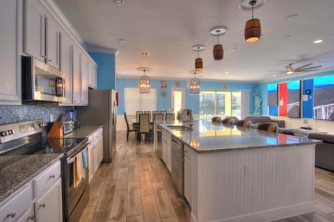 Experience culinary delight in this expansive kitchen with modern amenities and ample seating, perfect for large gatherings.