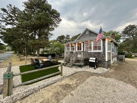 Turf yard, surrounded by sea shells. 4 Adirondack chairs, propane fire table.